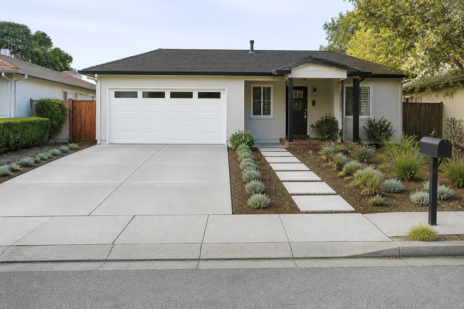 Before-and-after view of a front lawn redesigned as low-maintenance landscaping without grass: Permeable planting strips beside the driveway