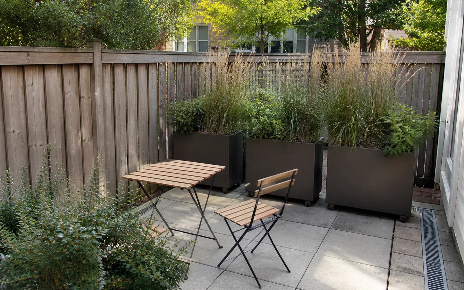 Small backyard landscaping inspiration: Use planters on casters as movable screens